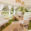 rattan sofa set with daybed and two single chairs with white cushions under a luxury marquee with flowers