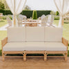 three seater rattan sofa lounge with white cushions under a marquee