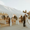 luxury white wedding marquee with bride and groom embracing