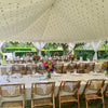 wedding marquee with stars on roof and tables and bamboo chairs