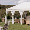 beautiful white tent for weddings with rattan furniture in an outdoor garden setting