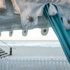 turquoise tent on the beach with white mirror detail on the valance which shows a white picket fence, some steps and the sea in the distance