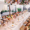 dinner setting with florals, bamboo folding chairs and tableware under a luxury marquee