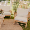cane rattan sofa lounge with white cushions on a jute mat under a luxury marquee
