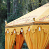 Luxury yellow octagonal shaped marquee for hire, Indian moroccan tipi bollywood in a beautiful garden setting closeup of valance