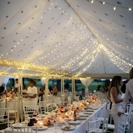 fairylights in the roof of a wedding marquee with table and flowers