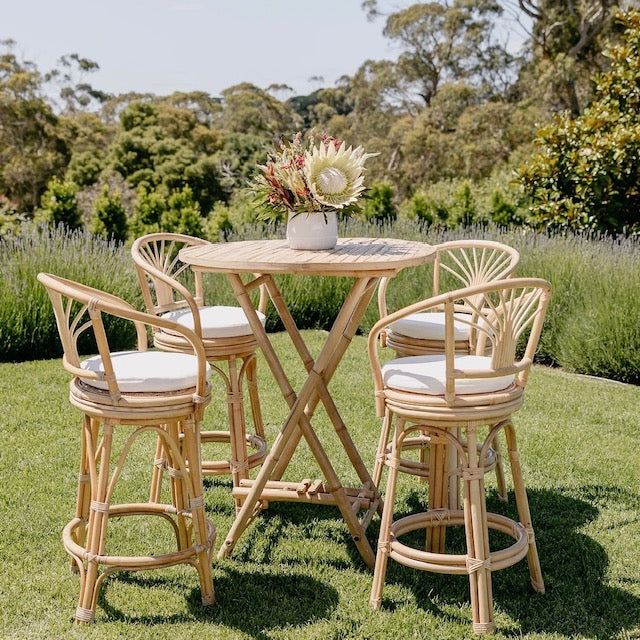 rattan bamboo high stool chairs with round table in a garden setting