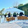 white Indian tent with brown sofas on a tennis court