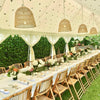 long lunch setting with bamboo chairs and rattan lamp shades under a white Indian tent by Exotic Soirees marquees
