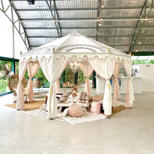 luxury tent pavilion in white with pretty pink styling on a low white table for a bridal party