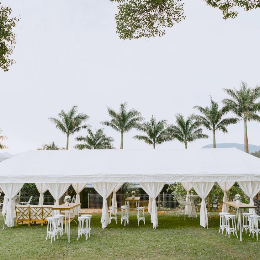 white wedding marquee with garden furniture and palms in the background